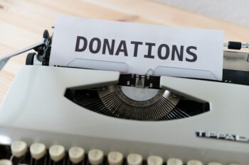Typewriter with piece of paper that says donations on it